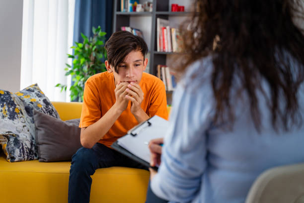 female psychologist counseling boy in office