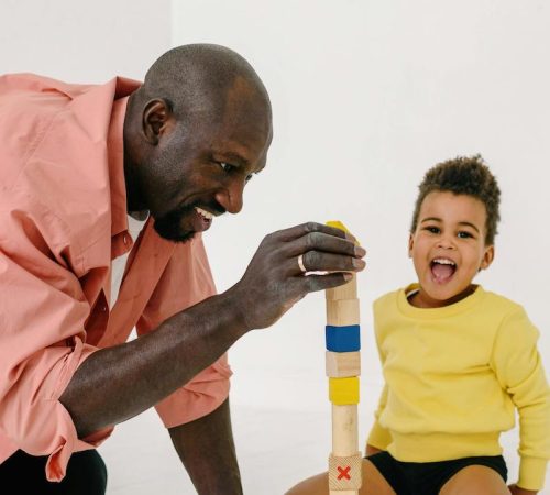 early connections child and family counseling therapist and young boy building tower together smiling-min early connections child and family counseling therapist and young boy building tower together smiling-min